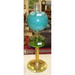 A late-19th/early-20th century oil lamp, the green glass reservoir on brass column and circular