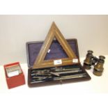 A wooden triangular Euchre board, 24cm, a small pair of binoculars, a case of drawing instruments