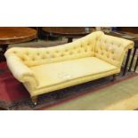 A Victorian chaise longue, the shaped back and seat with buttoned upholstery, on short turned legs