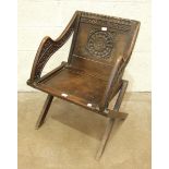 A copy of a mid-16th century hardwood folding chair, on X-frame, with carved back and arms, 87cm