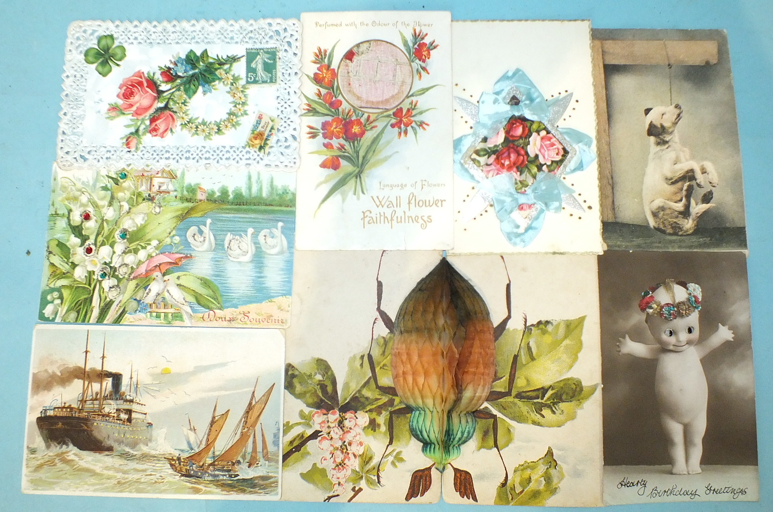 An album of 52 postcards, including a fold-out beetle card, silks, decoupage, hold-to-light,