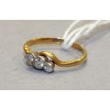 A three-stone diamond crossover ring in 18ct yellow and white gold mount, size K, 1.9g.