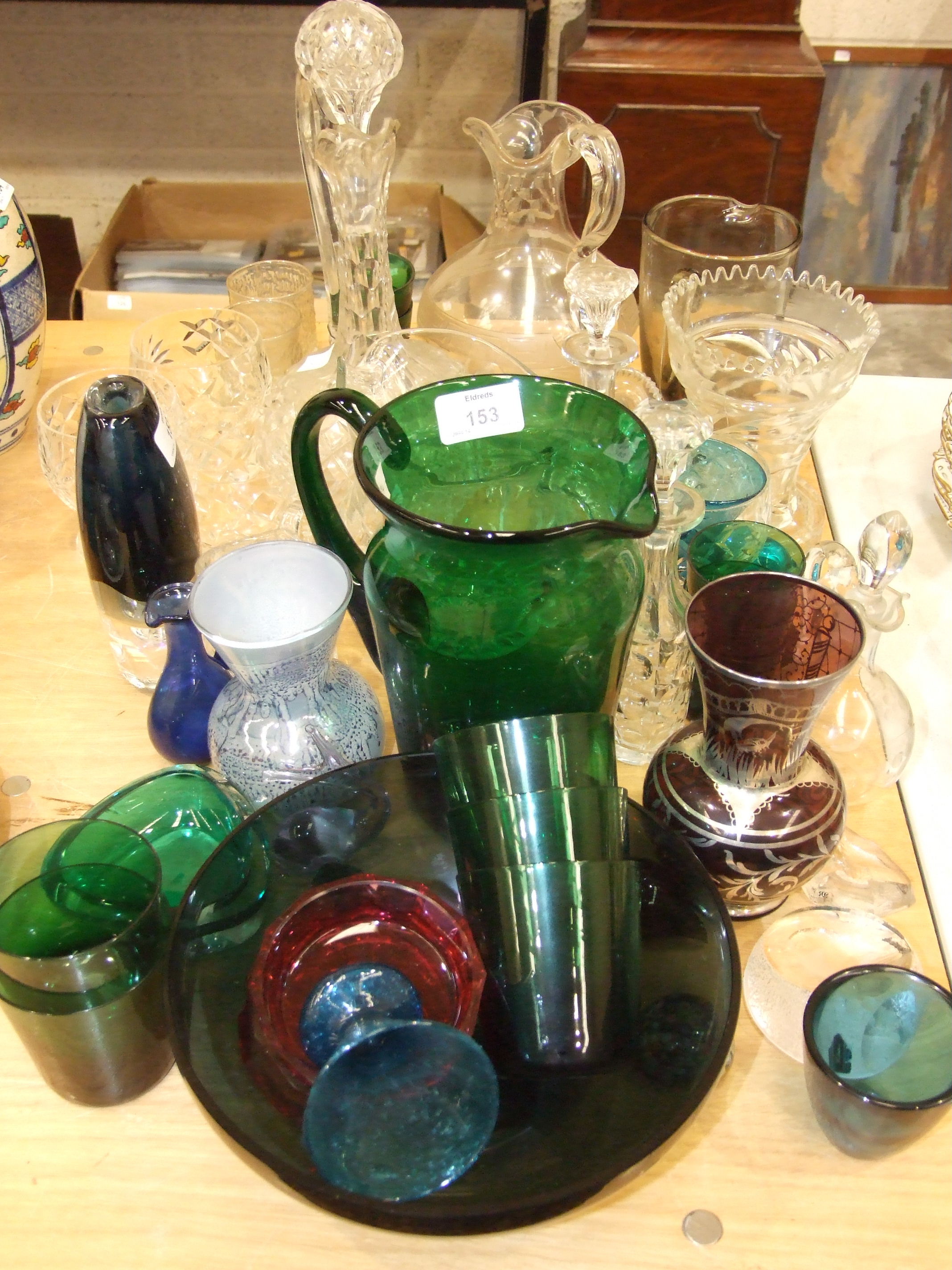 A collection of coloured and clear glassware, including decanters, jugs, vases, etc.