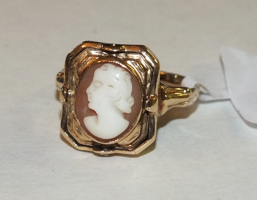 An unusual swivel ring with octagonal panel swivelling to show an oval shell cameo of a woman and an