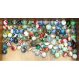 A collection of approximately one hundred glass marbles.