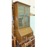 An Edwardian stained wood bureau/bookcase, the top fitted with a pair of leaded glass doors above