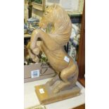 A glazed ceramic sculpture of a horse rearing and standing on its hind legs, on rectangular