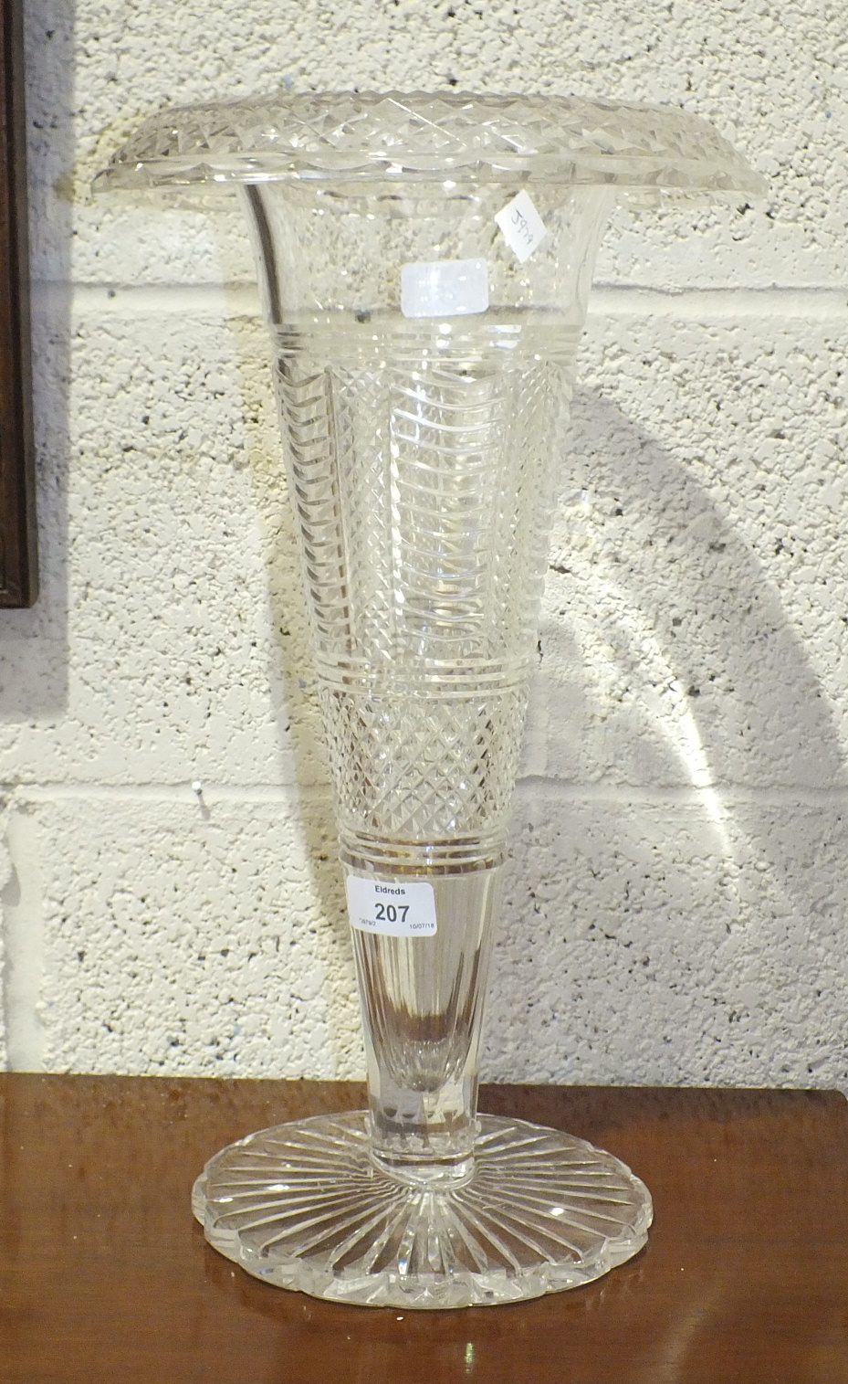 A large cut-glass trumpet shape vase with ribbed and hobnail decoration, on shaped circular base,