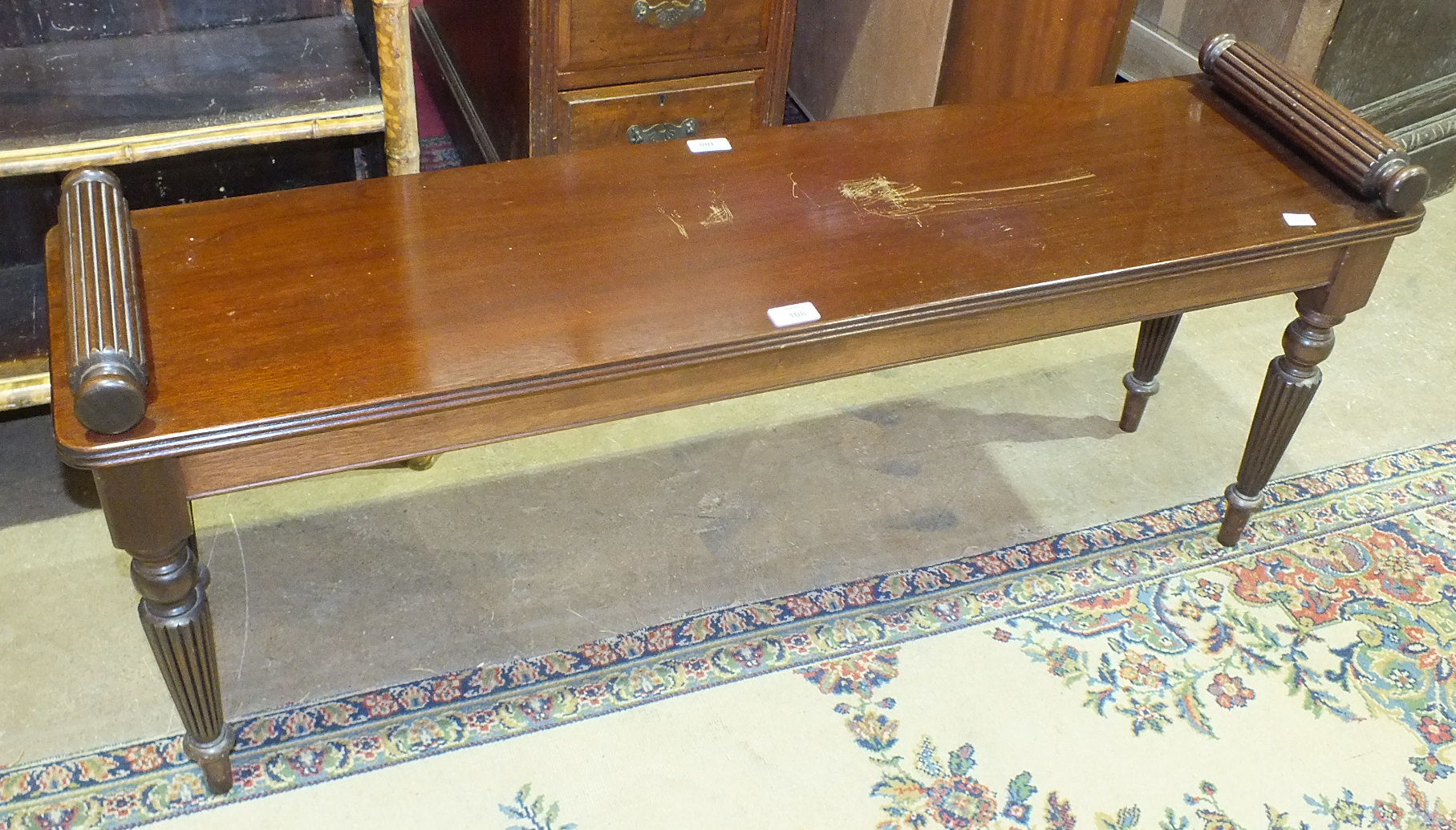 A reproduction Regency mahogany window seat with scroll ends, on turned and reeded supports, 121cm