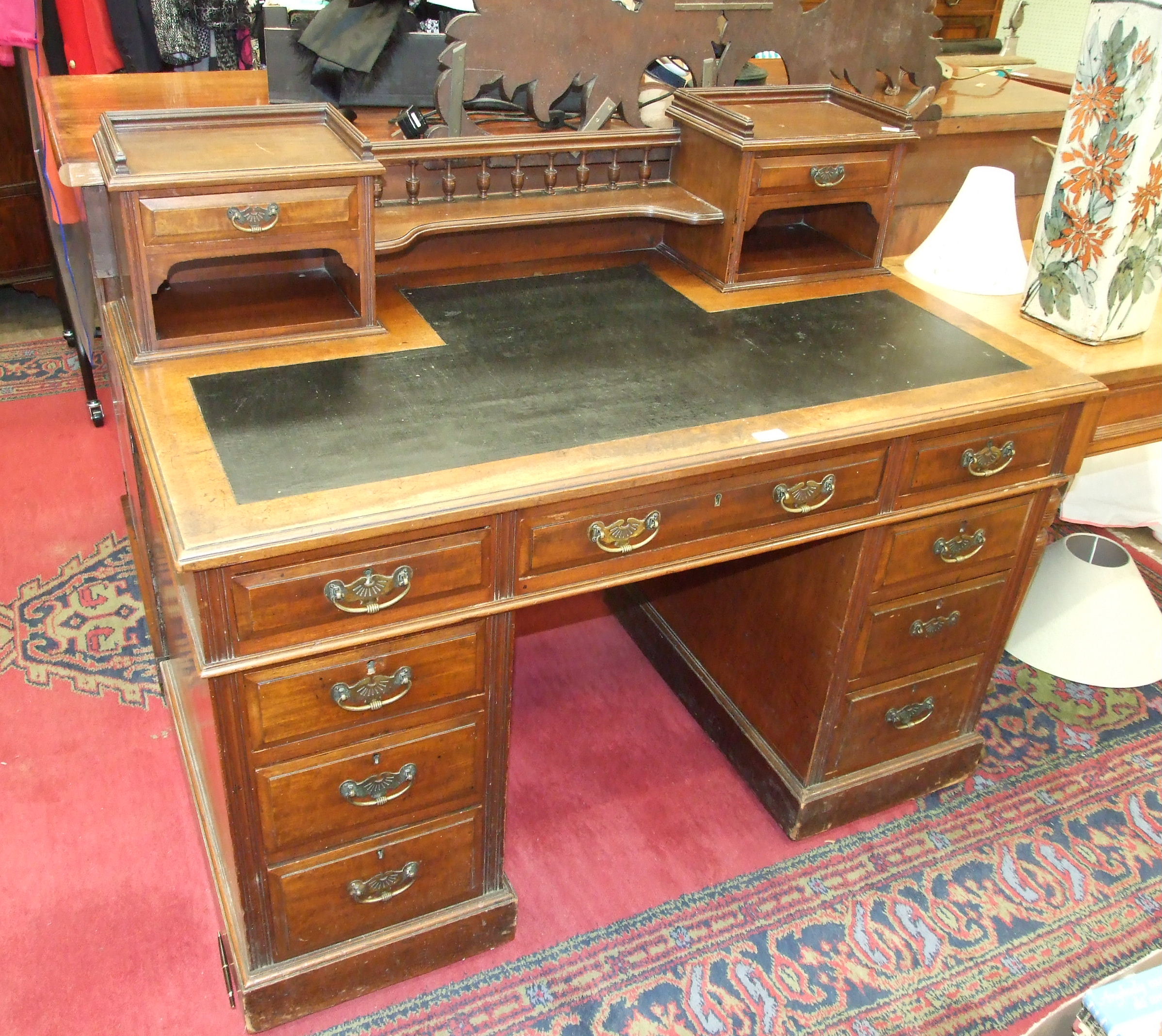 A Late-Victorian walnut knee-hole writing desk, the galleried top with two small drawers and writing