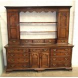 An 18th century Lincolnshire oak dresser, the moulded cornice above an arrangement of shelves, two