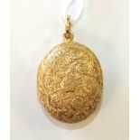 An unmarked yellow metal locket with scroll engraving, gross weight 9.5g.