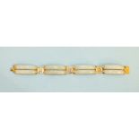 A modern Chinese jade bracelet of four pairs of curved jade batons united by 14ct yellow gold