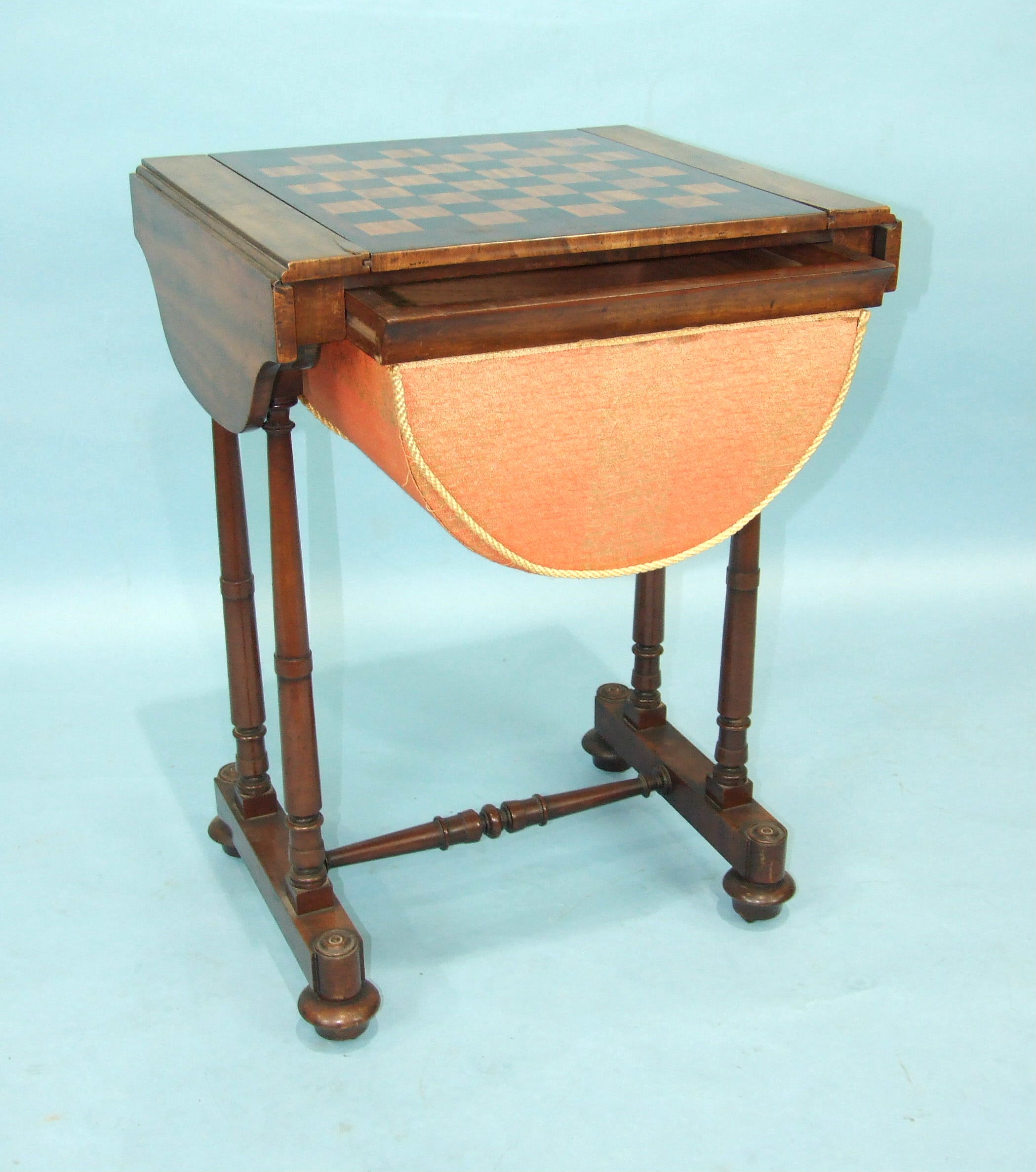 An Early-Victorian mahogany work and games table, the shaped top with two small drop leaves and