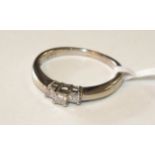 A 14ct white gold ring claw-set three princess-cut diamonds, size L½, 2g.