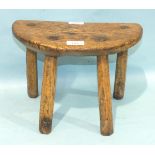 A charming 19th century elm rustic four-legged milking stool, the half-moon seat on four adzed