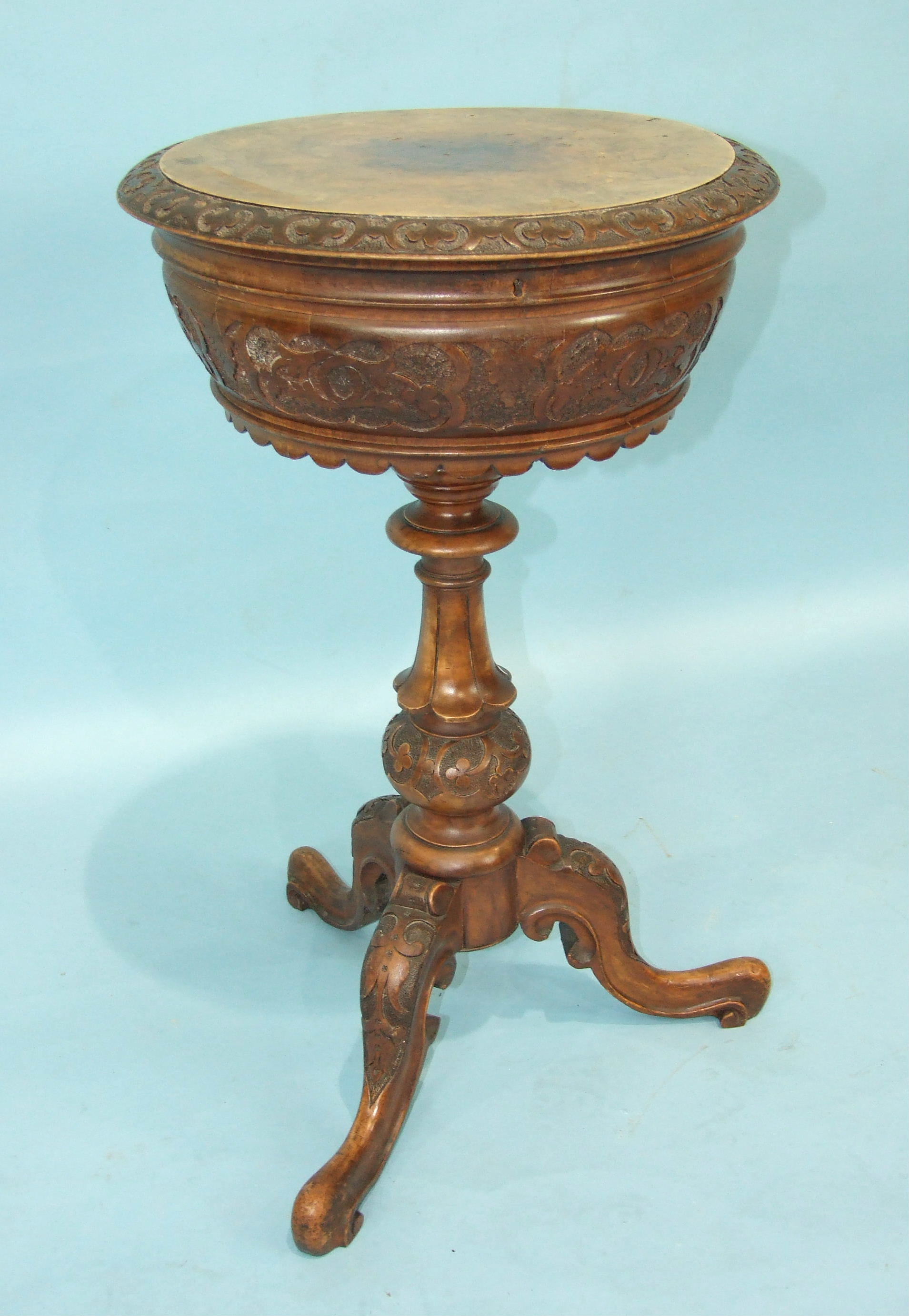 A Victorian carved walnut teapoy, the circular lid revealing two lined canisters and two later