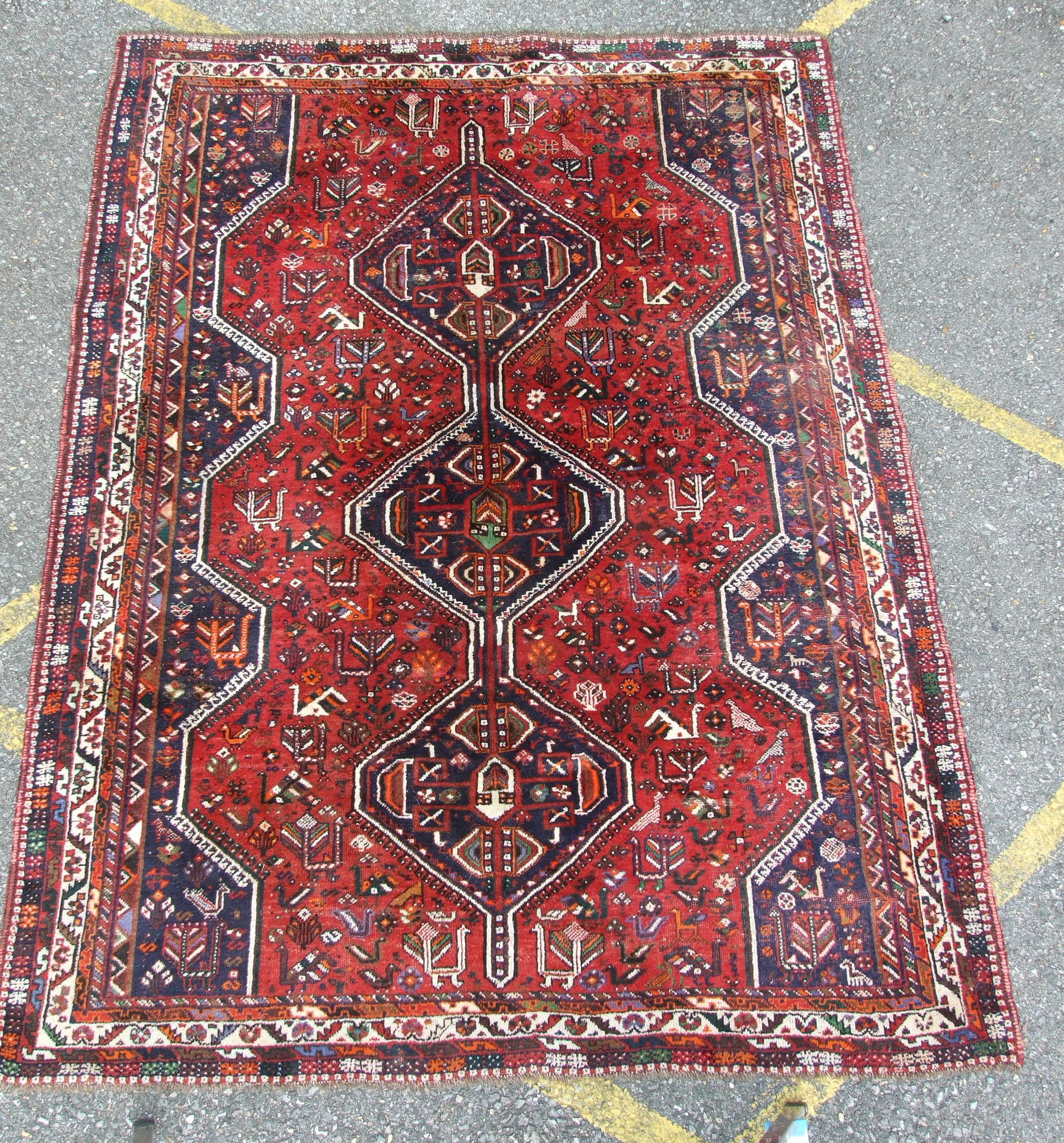 A Shiraz design wool carpet with triple pole medallion on crimson ground, 220 x 300cm, (some wear). - Image 2 of 2