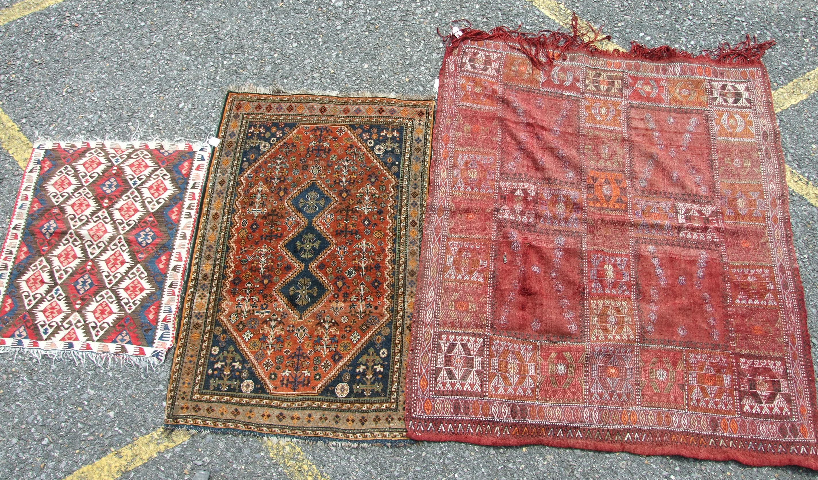 A Persian rug with triple pole medallion on brick red ground and blue spandrels, 87 x 133cm and