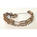 A 9ct rose gold gate-link bracelet with engine-turned links and padlock clasp, 18.6g.