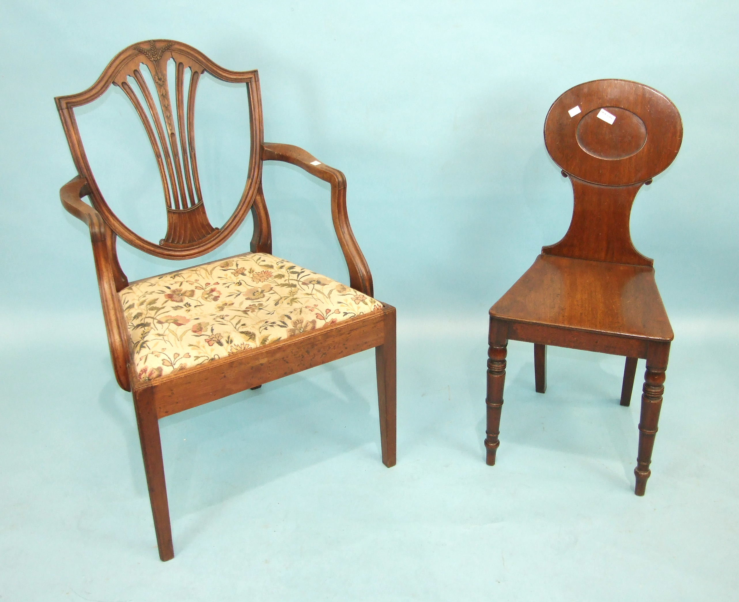 A Victorian mahogany hall chair, the solid back and seat on turned front legs and a Georgian