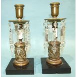 A pair of Victorian brass candle lustres, each with cut drops on black marble base, 25cm high, (