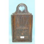 An antique carved fruit wood hanging candle box, the sliding door panel carved with a female