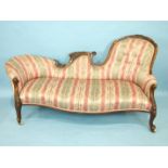 A Victorian walnut settee, the carved frame and cabriole legs with upholstered shaped back and