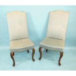 A set of eight Continental walnut dining chairs, each with upholstered high back and seat, on leaf-