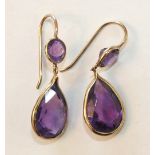 A pair of amethyst earrings, each with a round-cut faceted amethyst above a pendeloque-cut amethyst,