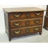 An early-18th century Continental chestnut or oak chest of three long drawers with heavy brass