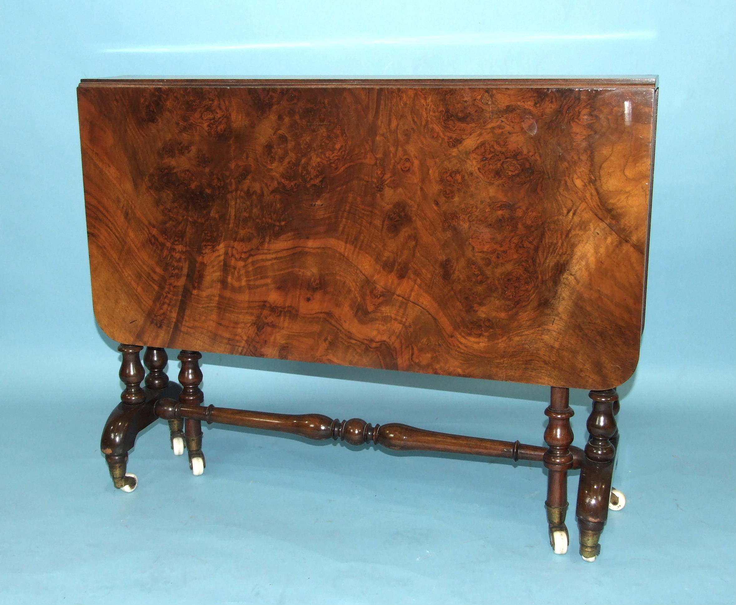 A Victorian figured walnut drop-leaf Sutherland table on turned legs with castors, 91cm x 101cm