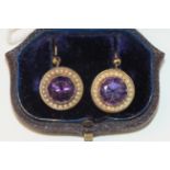 A pair of Victorian amethyst and pearl earrings, each set a round faceted amethyst within a