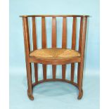 An Arts & Crafts-style oak slatted chair of cylinder shape, with serpentine-fronted drop-in rush