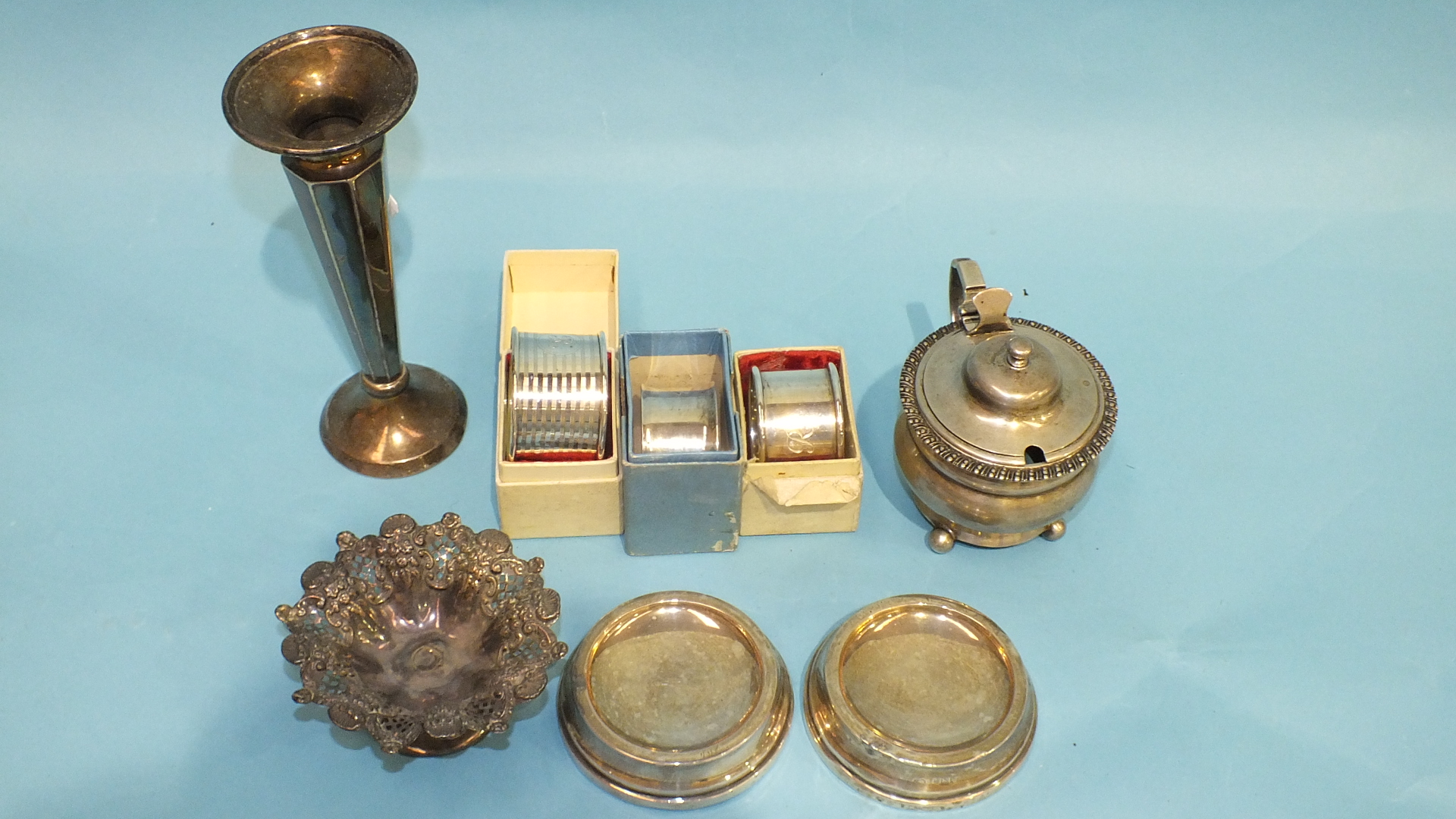 A silver mustard, (liner lacking), a silver spill vase, three napkin rings and two ashtrays, (a/