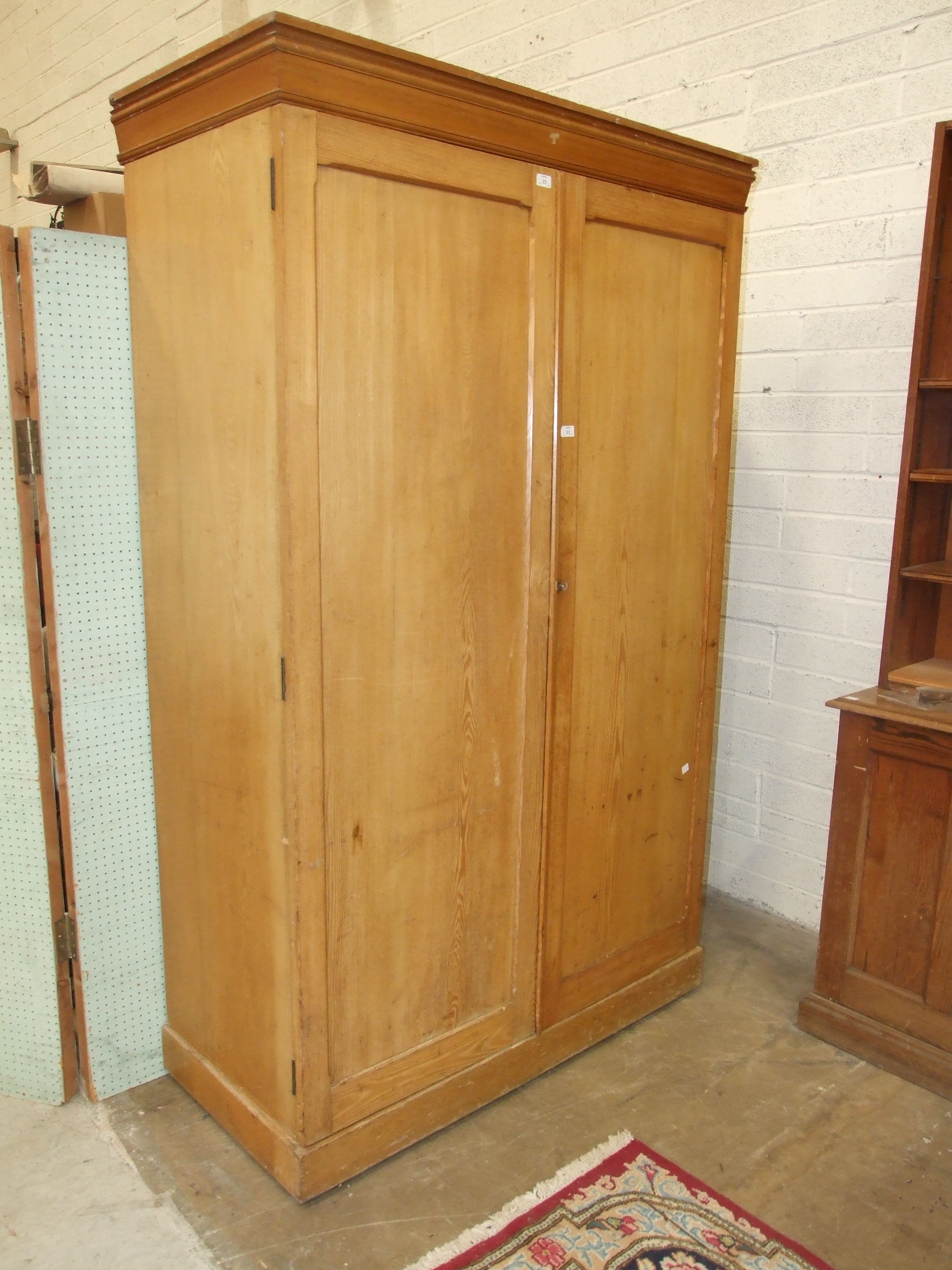 A stained pine two-door wardrobe, 123cm wide, 207cm high.