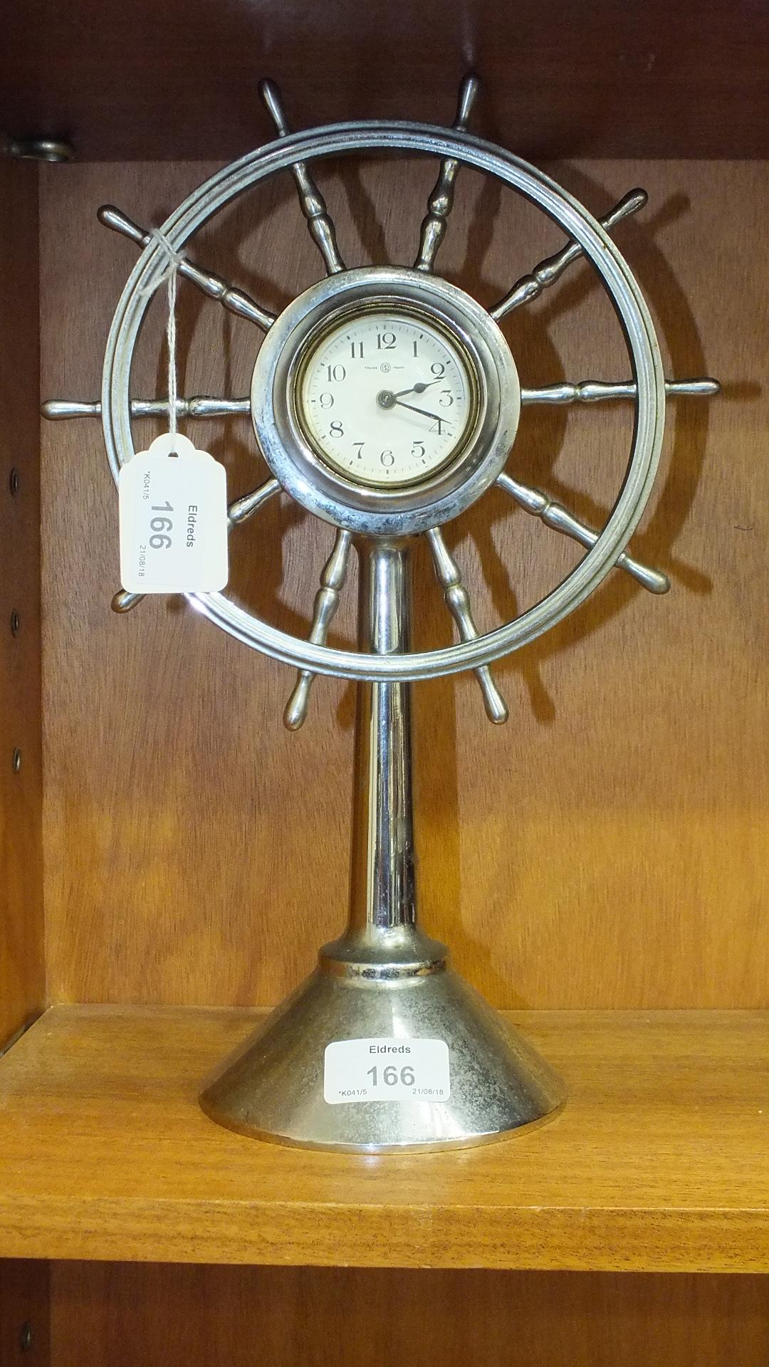 A chrome plated timepiece in the form of a ten-spoke ships wheel on stand, the dial with Arabic