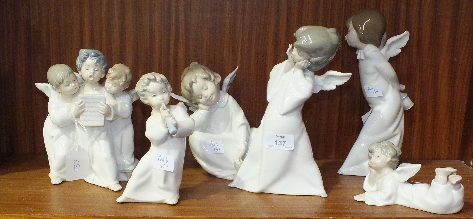 Six Lladro angelic figures, one playing a pipe, a group of three choristers and four others, (6).