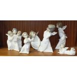 Six Lladro angelic figures, one playing a pipe, a group of three choristers and four others, (6).