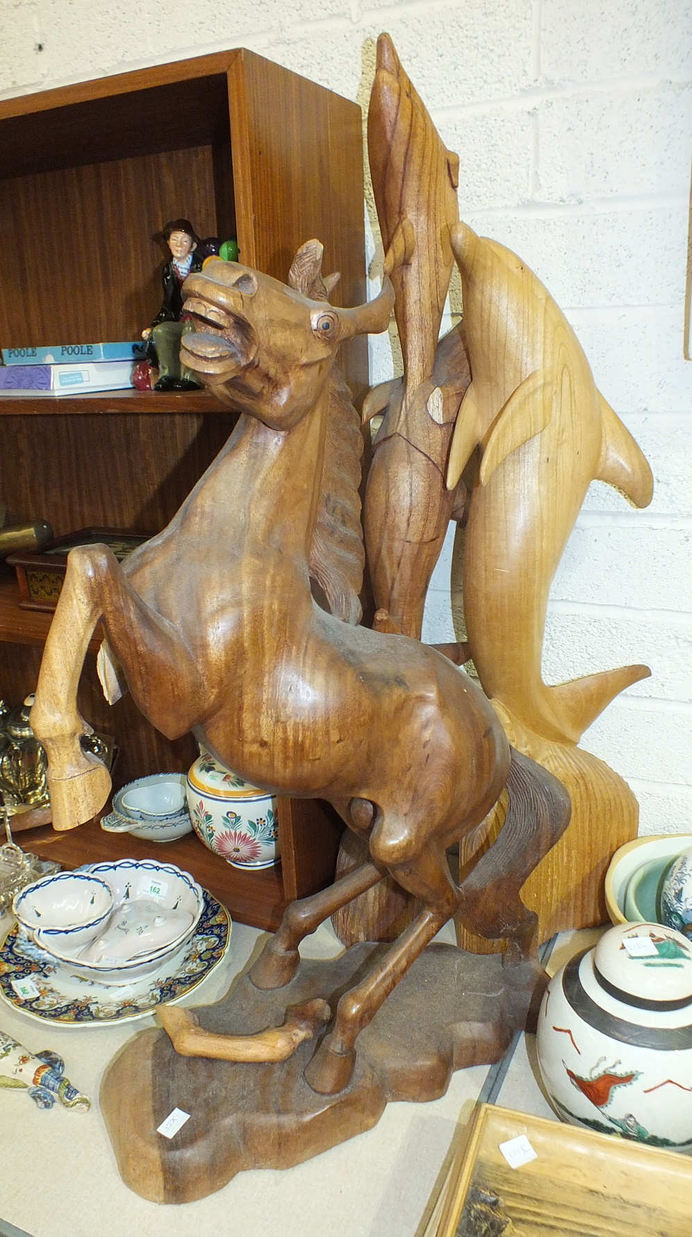 A carved wood figure of a leaping dolphin, 81cm high, another of three dolphins, 98cm high, (a/f)