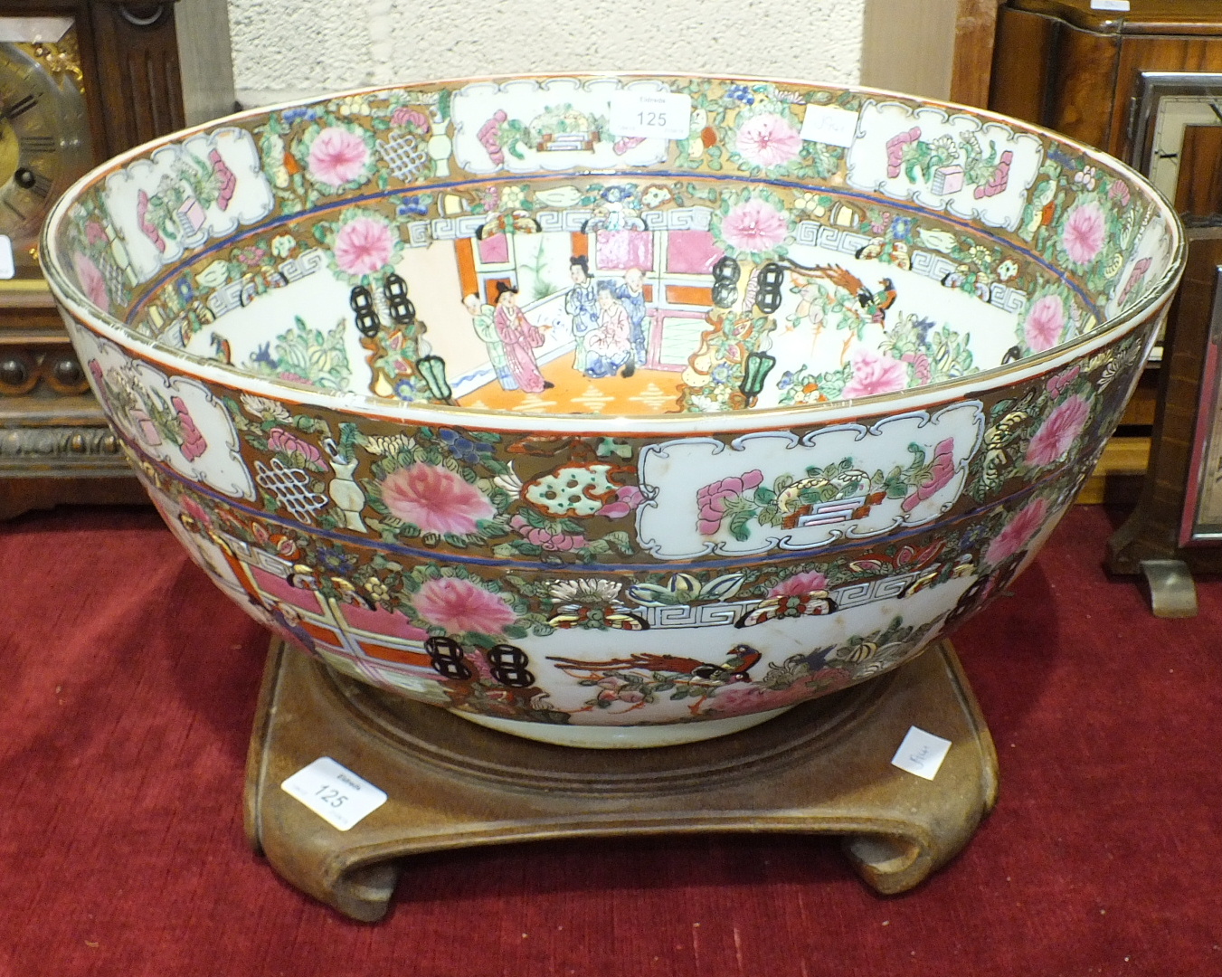 A reproduction Canton style porcelain punch bowl, 20cm high, on carved wood stand.