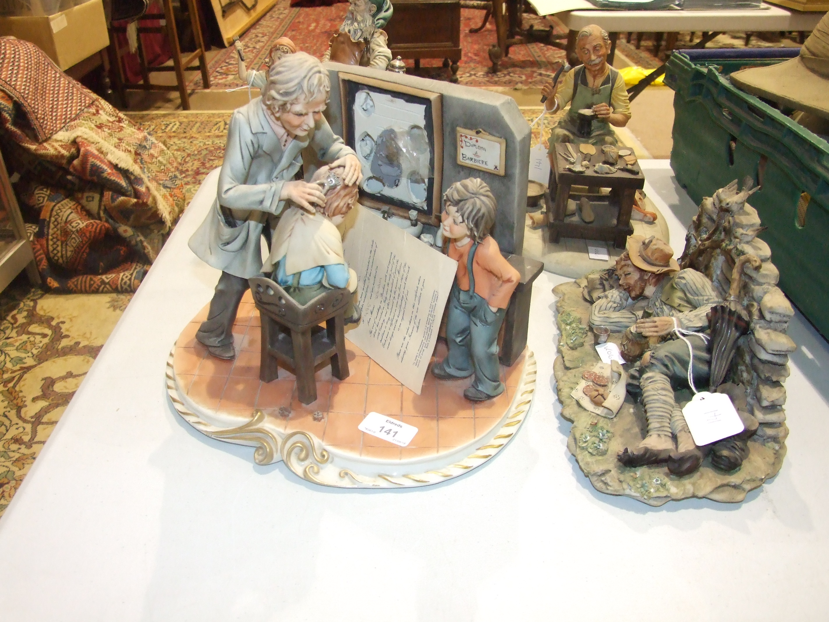 A modern Capo di Monte figure group, "The Barber" by Corti, 22cm high, another, "The Cobbler" and