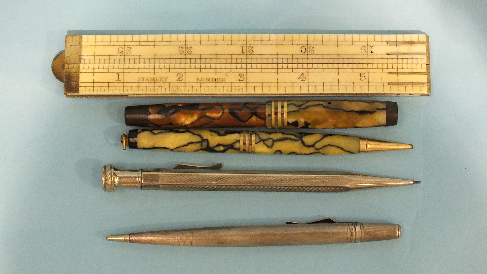 A Stanley of London folding 24" rule, a sterling silver propelling pencil and other items.