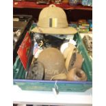 A WW2 steel helmet, a kukri knife with plated mounts, a pith helmet and other militaria and