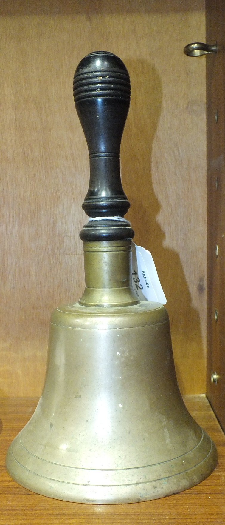 An early 20th century bronze hand bell with turned lignum handle, 26cm high.