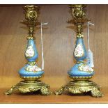 A pair of 19th century gilt metal and porcelain candlesticks, each gilt metal sconce and bottle-form