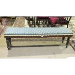 An upholstered stained wood window seat in the Victorian taste on fluted and turned legs, 151cm