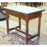 An enamelled top pine food preparation table, the rectangular top with brass edges above two end-