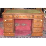 An Edwardian stained mahogany knee-hole desk, the rectangular top with writing inset, and three