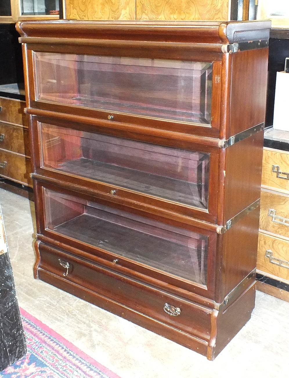 A Globe Wernicke-style three-tier stained mahogany bookcase with base drawer, 86cm wide, 106cm